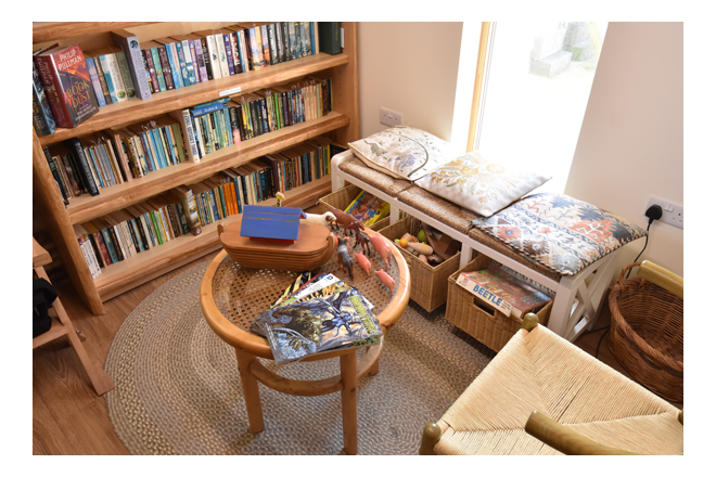 A table with a wooden toy ark, and baskets full of plastic animals and board games